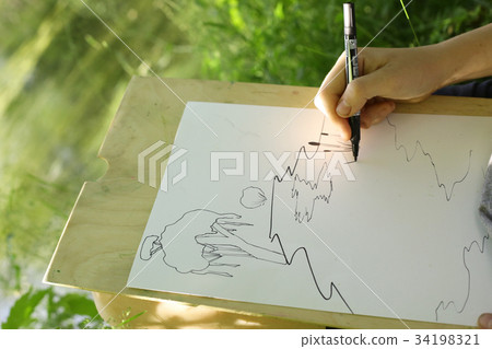 hand with pencil drawing on the nature 34198321