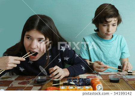 teenager boy and girl with japanese sushi roll teenager boy and girl with japanese sushi roll 34199142