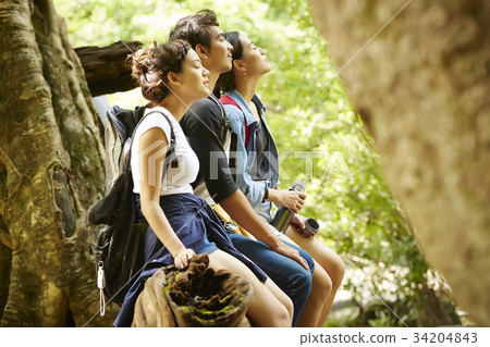 three people are taking a deep breath of fresh air in a forest. three people are taking a deep breath of fresh air in a forest. 34204843
