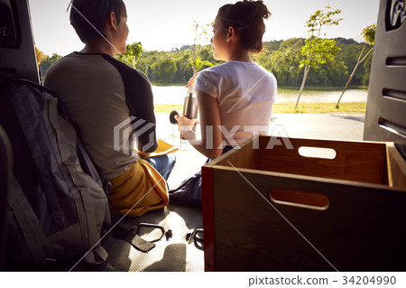 A young couple is chatting and looking together in the car 34204990