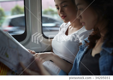 two young girls are looking the map inside a truck 34205031