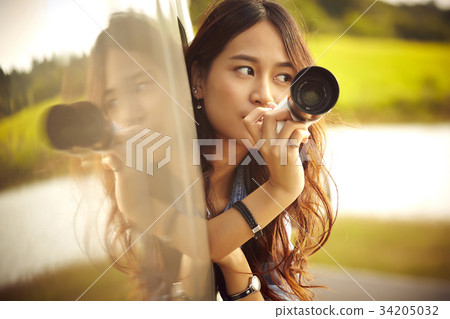 an asian girl is taking a photo from the truck an asian girl is taking a photo from the truck 34205032