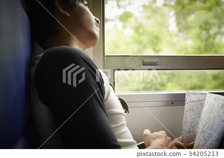 The man is watching the sky through the train window. The man is watching the sky through the train window. 34205213