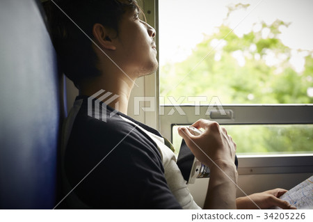 The man is looking for beautiful scenes to take pictures from a train The man is looking for beautiful scenes to take pictures from a train 34205226