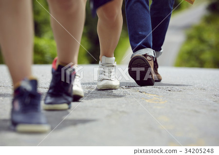 The footsteps of three people walking on a road The footsteps of three people walking on a road 34205248
