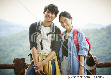 The happy couple is standing and posing to take photos when travelling 34205262