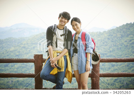 The boy and girl are standing and smiling 34205263