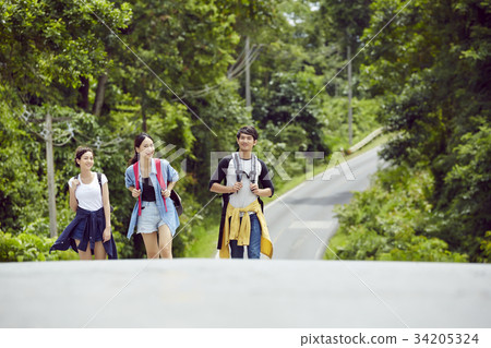 three dynamic people are talking together when walking in the jungle three dynamic people are talking together when walking in the jungle 34205324