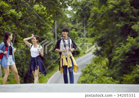 three travellers are walking and chatting together on the road in the jungle three travellers are walking and chatting together on the road in the jungle 34205331
