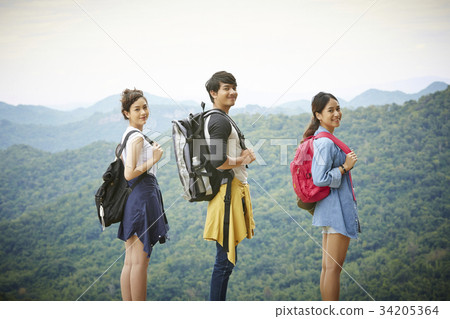 three asian people with smile and backpacks are standing together three asian people with smile and backpacks are standing together 34205364