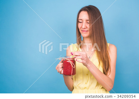 Beautiful young woman holding strawberry smoothie 34209354