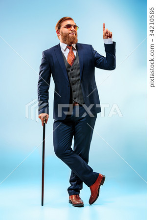 The barded man in a suit holding cane. The barded man in a suit holding cane. 34210586