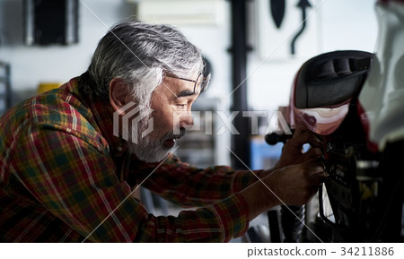 修理摩托車的老人 34211886