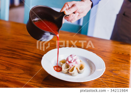 The side photo of the waitress pouring the borsch The side photo of the waitress pouring the borsch 34211984