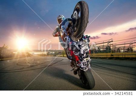 圖庫照片: moto rider making a stunt on his motorbike