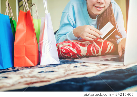 Woman shopping online using laptop credit card Woman shopping online using laptop credit card 34215405
