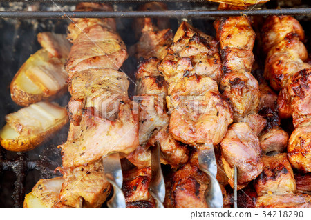 The smoke rises over the fried meat skewers 34218290