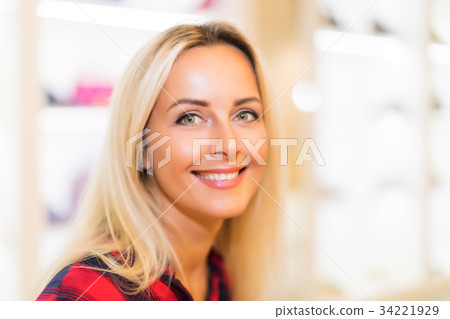 Portrait of young smiling woman in fashion store 34221929