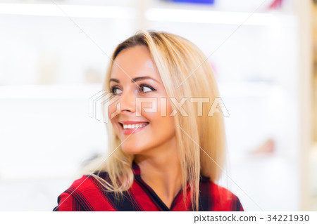 Portrait of young smiling woman in fashion store 34221930