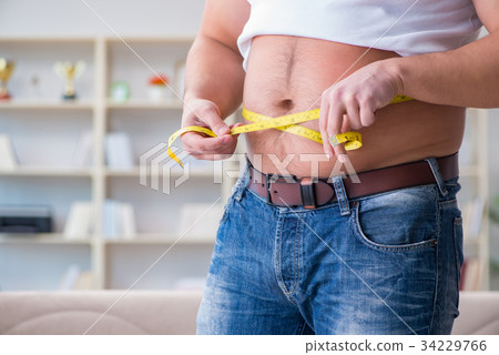 Man suffering from extra weight in diet concept 34229766