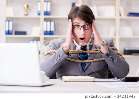 Businessman tied up with rope in office Businessman tied up with rope in office 34231442