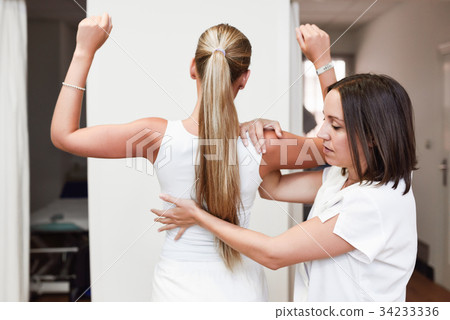 Medical check at the shoulder in a physiotherapy center. Medical check at the shoulder in a physiotherapy center. 34233336