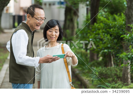 Senior operating a smartphone (fresh green) 34239095