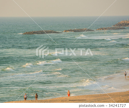 People walking on the beach of the Mediterranean People walking on the beach of the Mediterranean 34241727