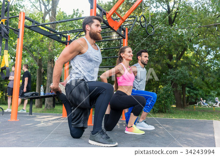 Three determined friends doing stretching Three determined friends doing stretching 34243994
