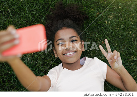 Smiling girl taking selfie on her smartphone Smiling girl taking selfie on her smartphone 34258101