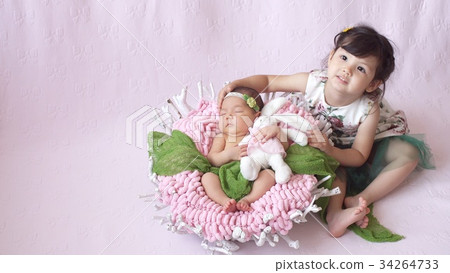 little girl looks at her baby sister. 34264733