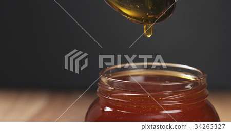 honey pour with spoon in glass jar honey pour with spoon in glass jar 34265327