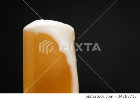 wheat unfiltered beer poured into glass over dark 34265718