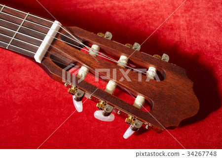 acoustic guitar on red fabric, closeup objects 34267748