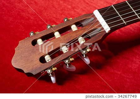 acoustic guitar on red fabric, closeup objects acoustic guitar on red fabric, closeup objects 34267749