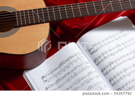 acoustic guitar on red fabric, closeup objects 34267792