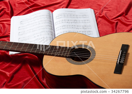 acoustic guitar on red fabric, closeup objects acoustic guitar on red fabric, closeup objects 34267796