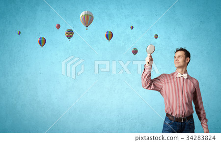 Guy looking in magnifying glass Guy looking in magnifying glass 34283824