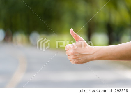 Close up woman hand hitchhiking at countryside Close up woman hand hitchhiking at countryside 34292258