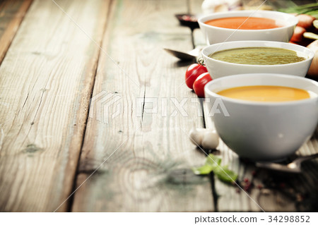 Variety of cream soups over old wood background Variety of cream soups over old wood background 34298852