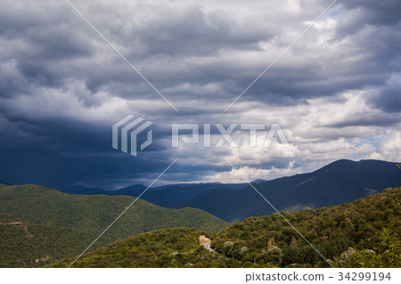 Green mountain covered with forest on the blue sky 34299194