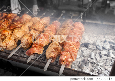 Grilled kebab cooking on metal skewer. Grilled kebab cooking on metal skewer. 34299217