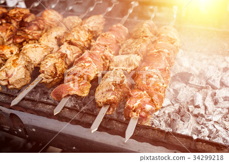 Grilled kebab cooking on metal skewer. Grilled kebab cooking on metal skewer. 34299218
