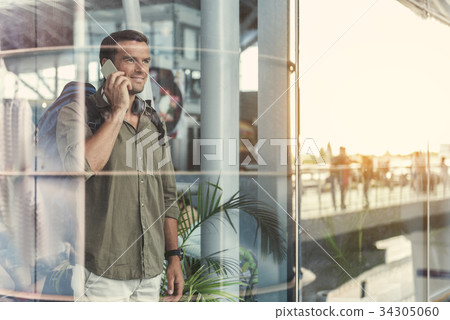 Joyful guy is having conversation on smartphone 34305060