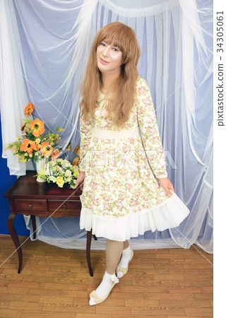 米色花裙子一件式全長微笑的女人抱著一條左手的裙子 米色花裙子一件式全長微笑的女人抱著一條左手的裙子 34305061