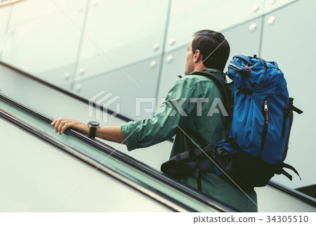 Pleasant adult man is standing on staircase 34305510