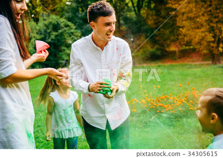 cute european family plaing with holi paints in 34305615
