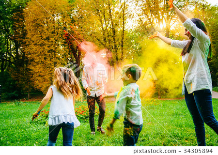 cute european family plaing with holi paints in 34305894