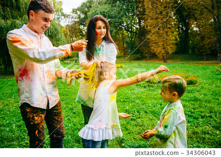 cute european family plaing with holi paints in cute european family plaing with holi paints in 34306043
