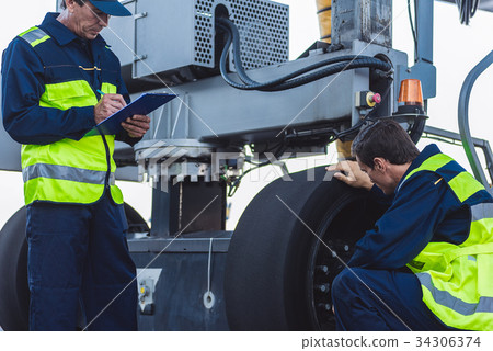 Calm workers controlling aircraft machine 34306374